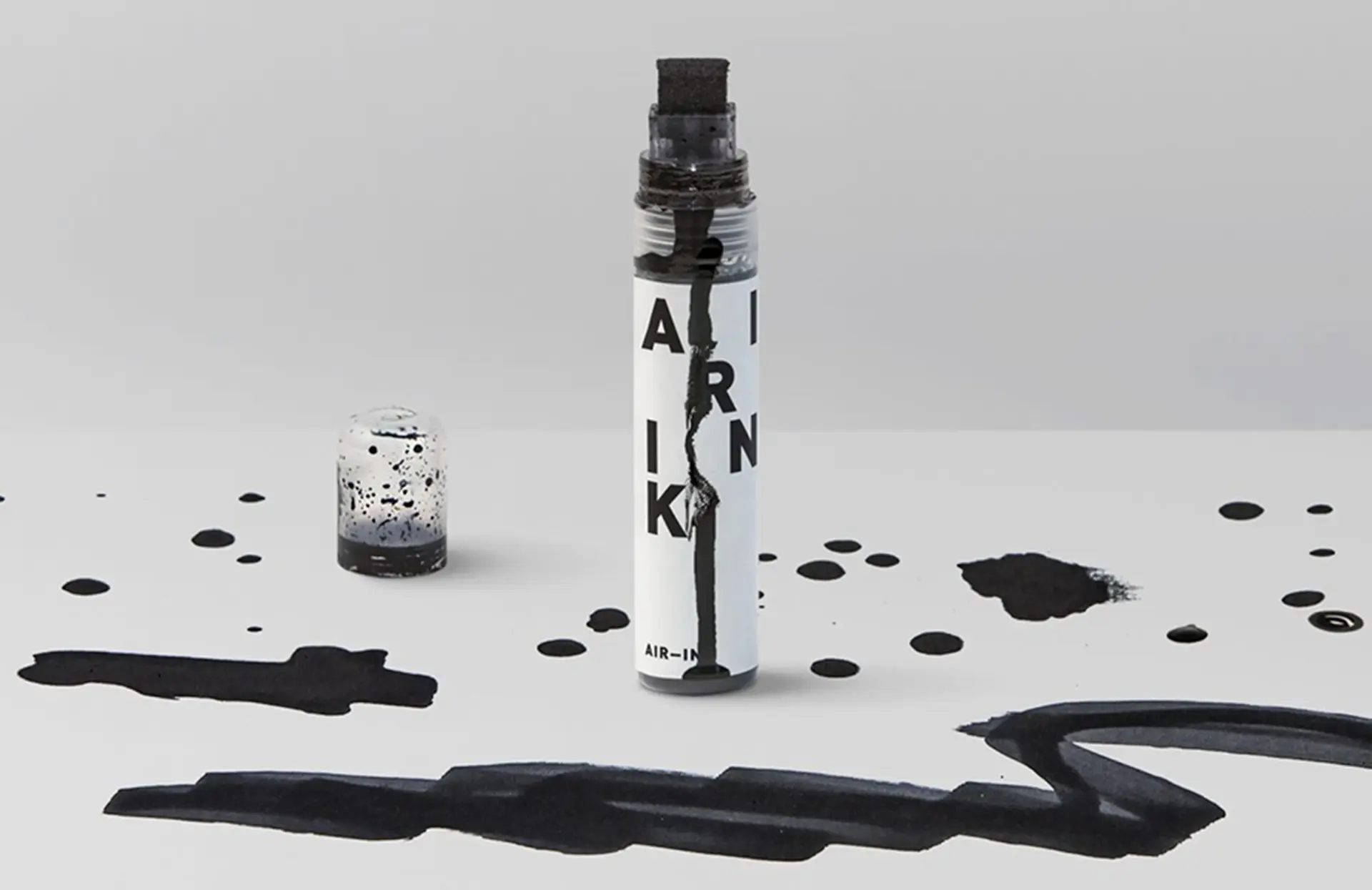 An Air-Ink marker containing ink made from pollution, placed on a black-stained surface.